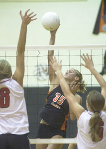 Coldwater's Tiffany Uhlenhake, 35, splits two Wapakoneta defenders for a kill during their match on Saturday at the Knap's invitational at The Palace. Coldwater lost in the finals of the three-team invite to state-ranked Ottawa-Glandorf.<br>dailystandard.com