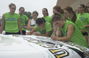 Celina High School volleyball players sign a banner showing their commitment to use seat belts -- one of several programs under way in hopes of stemming the tide of traffic fatalities involving teenagers. Ten young people, ranging in age from 14 to 19, have died in Mercer and Auglaize counties this year. The banners will be carried or displayed at Friday night's Celina-Wapakoneta football game.<br>dailystandard.com