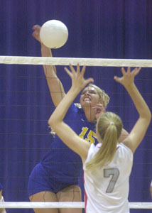 Marion Local's Kelsey Schaefer, 15, spikes the ball past New Knoxville's Alycia Niemeyer during their match on Thursday. <br>dailystandard.com