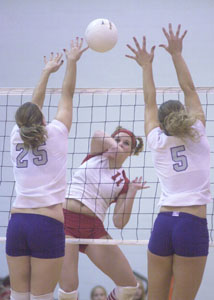 St. Henry's Betsy Hoying, 11, tries to spike the ball in between Fort Recovery blockers, Kelly Link, 25, and Krystal Rammel, 5, during their match on Saturday in Division IV sectional action at New Bremen.<br>dailystandard.com