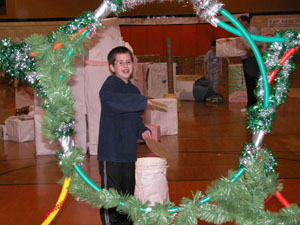 Fourth-grader Connor Stammen gives a cardboard frisbee a whirl to see if he can get it through one of five improvised holiday wreaths on the obstacle course at Coldwater Schools.<br>dailystandard.com