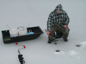 Tim Heindel of Mercer enjoys a little 'fair weather' ice fishing this week in a channel of Grand Lake along U.S. 127. As area temperatures become unseasonably warm, state park officials worry about the safety of those who venture out onto the previously frozen water.<br>dailystandard.com