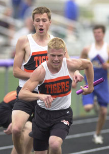 Versailles' Ryan Langenkamp, back, hands the baton off to teammate Jordan Rindler, front, during the 800-meter relay on Friday at the Midwest Athletic Conference meet. <br>dailystandard.com