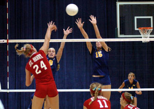 St. Henry's Bethany Puthoff, 24, tries to hit the ball past Marion Local's blocking tandem of Abby Niekamp, 15, and Maria Moeller, 9, during their Midwest Athletic Conference match on Thursday. St. Henry defeated Marion Local in three games to stay unbeaten in the MAC.<br>dailystandard.com