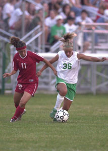 Celina's Cayla Hellwarth, 36, dribbles the ball upfield as Shawnee's Brooke Shultz, 11, tries to make a defensive play. The Bulldogs defeated the Indians, 1-0 to stay unbeaten on the year after five games.<br>dailystandard.com