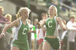 Celina's Eryn Langenkamp, right, passes the baton to teammate Cayla Hellwarth, left, during the 1,600-meter relay on Thursday against Van Wert at the High School Track. The Celina girls and boys each defeated Van Wert in the dual meet.<br></br>dailystandard.com