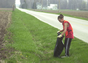 Afton Canary picks up roadside litter, doing her part to keep Hopewell Township clean. The county supplies garbage bags, rubber gloves and dumpsters for this project.<br></br>dailystandard.com