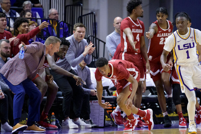 Alabama head coach Nate Oats, left, cheers for Alabama guard Rylan Griffen, center bottom, after he made a three point basket next to LSU guard Cam Hayes (1) during the second half of an NCAA college basketball game in Baton Rouge, La., Saturday, Feb. 4, 2023. (AP Photo/Matthew Hinton)