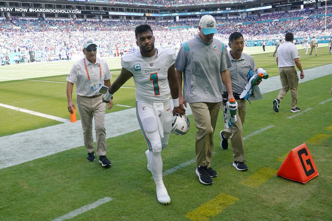 Miami Dolphins quarterback Tua Tagovailoa (1) is assisted off the field after he was injured during the first half of an NFL football game against the Buffalo Bills, Sunday, Sept. 25, 2022, in Miami Gardens, Fla. (AP Photo/Wilfredo Lee )